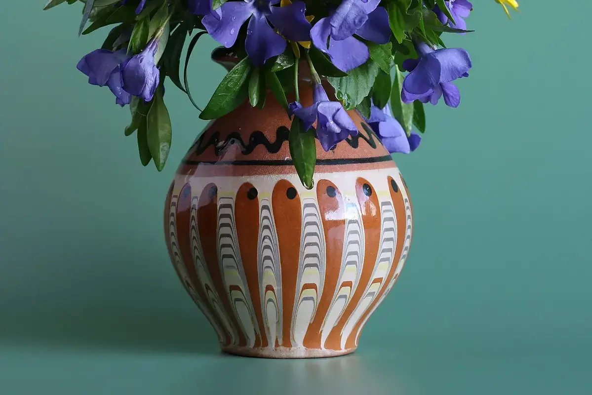 Flower heads turning sideways beside upright stems in a clear vase